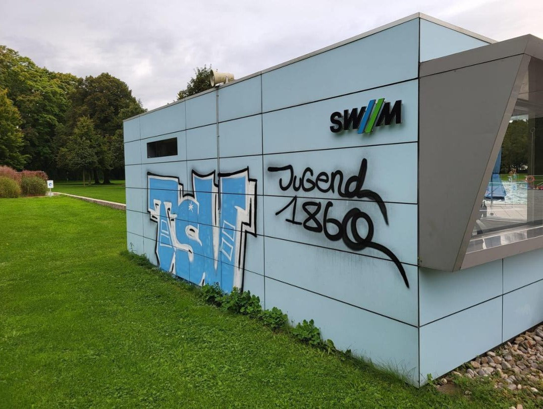 Graffiti auf Glas- und Metallflächen vor der Entfernung in München